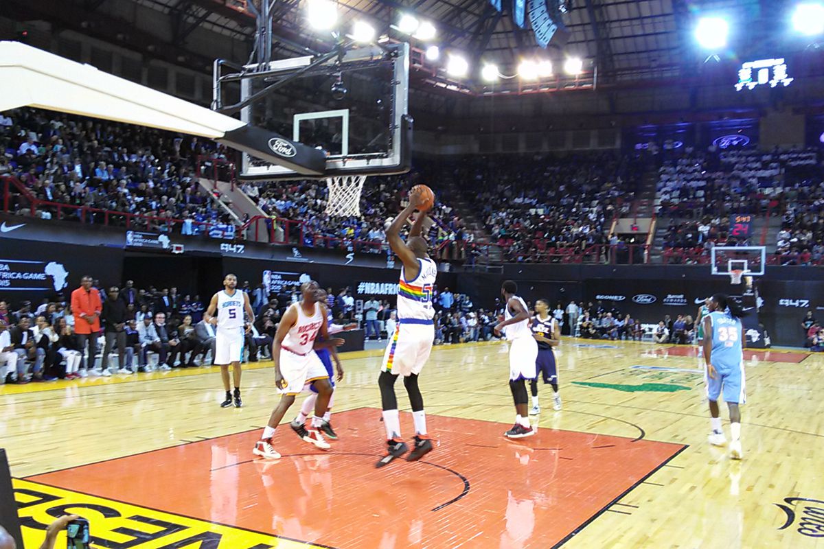 Nuggets legend Dikembe Mutombo doing what he does best, pulling down a rebound.