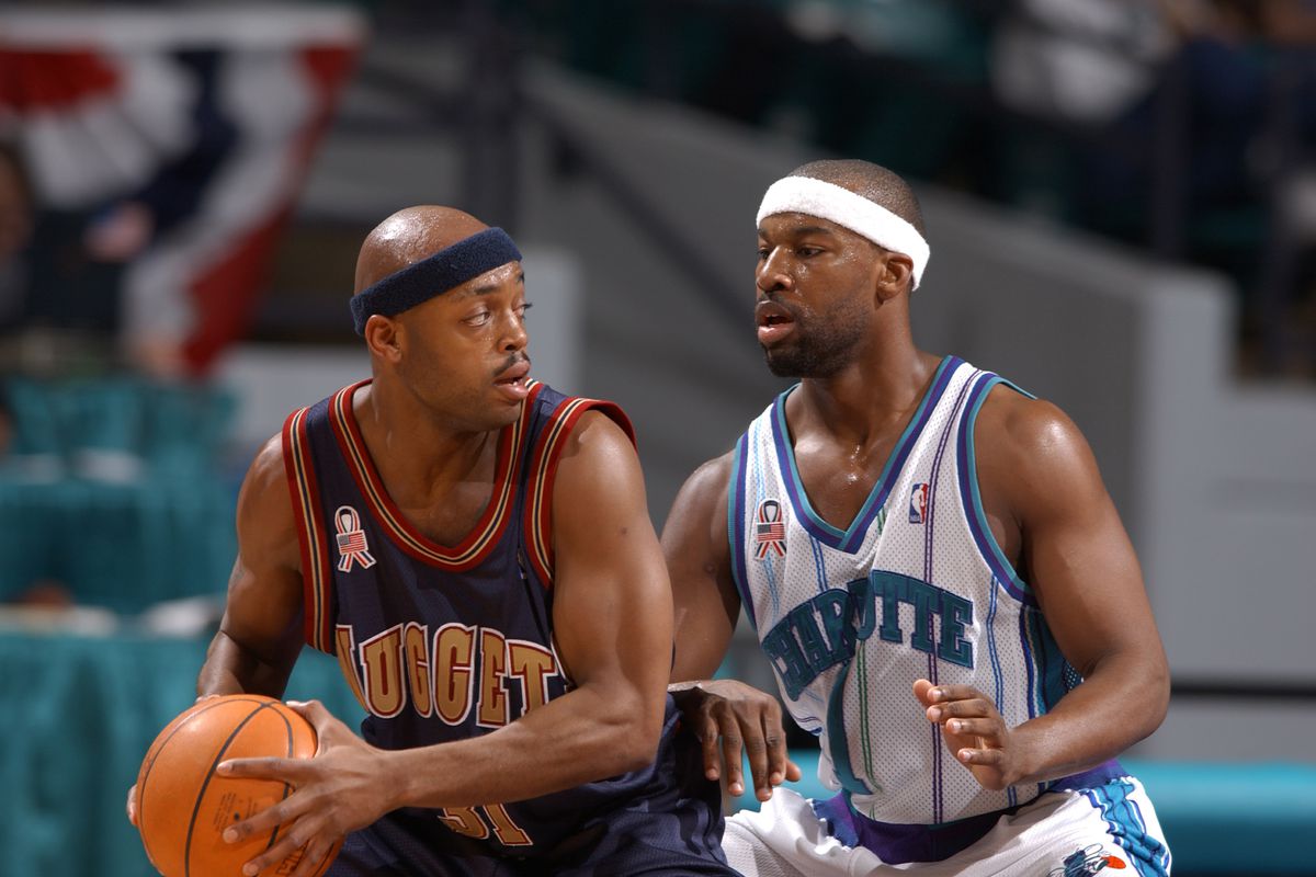 Baron Davis #1 of the Charlotte Hornets tries to contain Nick Van Exel #31 of the Denver Nuggets in Charlotte, North Carolina.